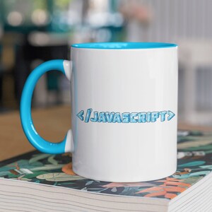 Może przedstawiać: Biały kubek ceramiczny z niebieskim rantem i uchwytem. Kubek ma napis "< / JAVASCRIPT >" nadrukowany z przodu niebieską, pikselową czcionką.