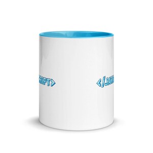Peut inclure: Une tasse en c&eacute;ramique blanche avec un bord bleu clair. La tasse porte le texte "<script>" sur le c&ocirc;t&eacute; gauche et "</javascript>" sur le c&ocirc;t&eacute; droit. Le texte est en police bleue pixelis&eacute;e.