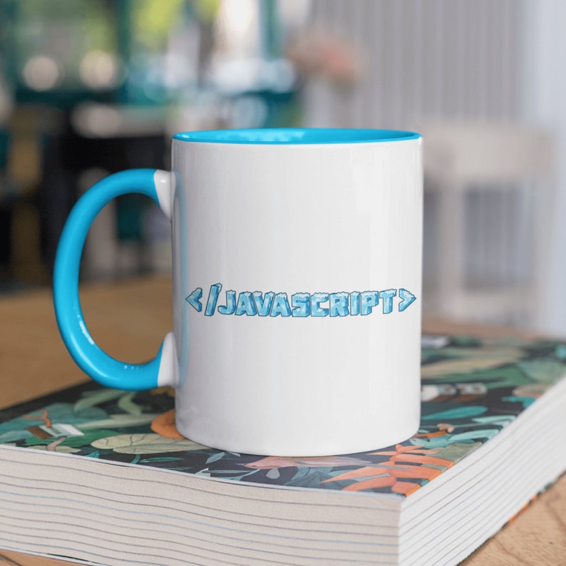 Peut inclure: Une tasse en c&eacute;ramique blanche avec un bord et une anse bleus. La tasse porte l'inscription "< / JAVASCRIPT >" imprim&eacute;e sur le devant en police bleue pixelis&eacute;e.