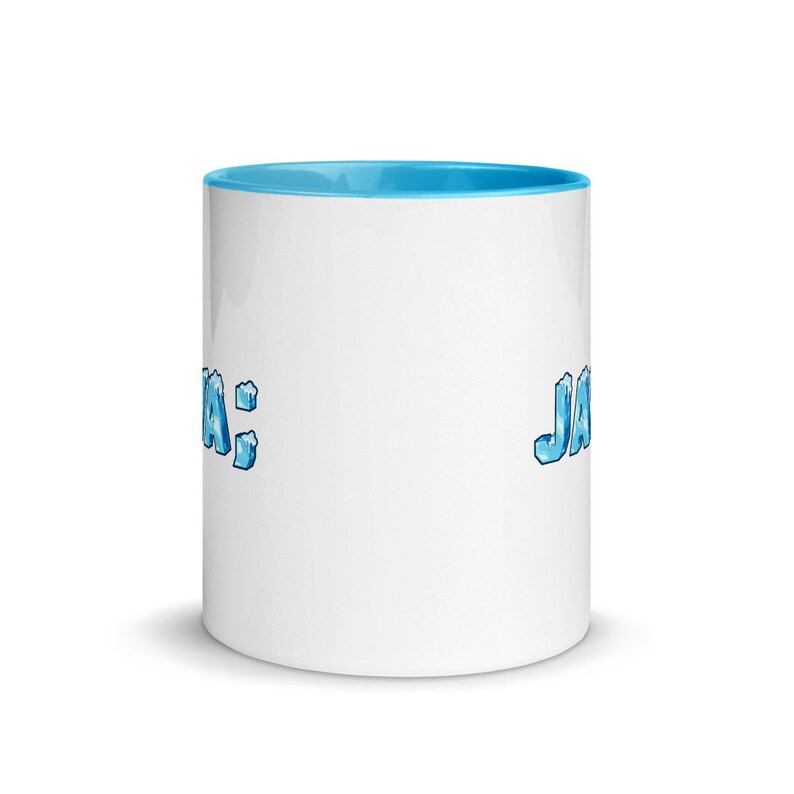 Puede incluir: Taza de cer&aacute;mica blanca con un borde azul claro y un gr&aacute;fico helado azul que dice "JA" a la derecha y "JA" a la izquierda.
