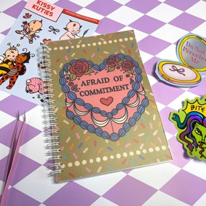 May include: A set of stickers featuring various designs, including a heart-shaped cake with the text "Afraid of Commitment", a bee and ladybug, a baby with a bow, a compact with the text "Do Not Perceive Me", and a green snake with the text "Bite Back".