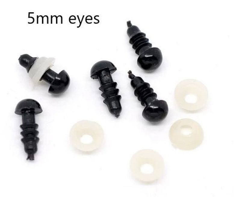 May include: Black plastic safety eyes with washers for crafts. The text "5mm eyes" is in the upper left corner. The eyes are black with a rounded head and a threaded post. White washers are also included.