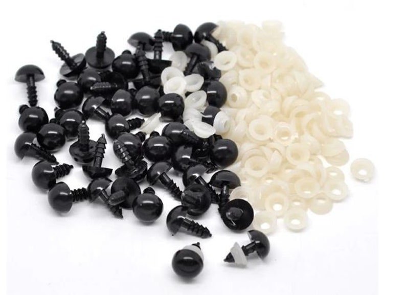 May include: A selection of black plastic safety eyes with screw-on backs and white plastic washers. These craft supplies are used for making soft toys, dolls, and other handmade projects. The eyes are round and shiny.
