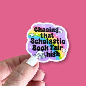 May include: A sticker with a rainbow background and the text "Chasing that Scholastic Book Fair high".