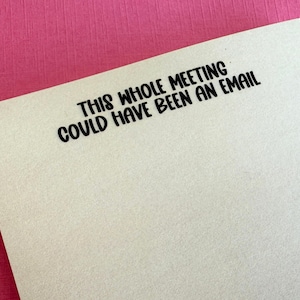 May include: A beige notepad with the text "This whole meeting could have been an email" printed in black.