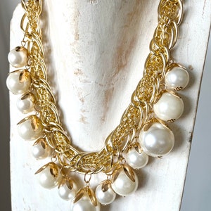 “Marrakesh” necklace in gold-colored zamak chain and ivory-colored resin pearls.