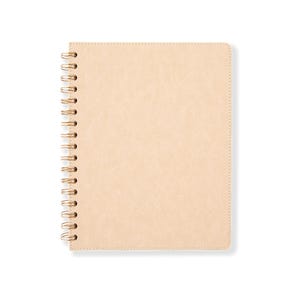Puede incluir: Un cuaderno beige con espiral y cubierta texturizada. El cuaderno tiene una encuadernación en espiral dorada y un borde cosido. La cubierta es de color liso y neutro, y el cuaderno está sobre un fondo blanco.