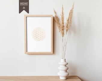 May include: A framed print of a gold geometric pattern, known as the Flower of Life, against a white background. The print is displayed on a white wall next to a white vase with dried pampas grass.