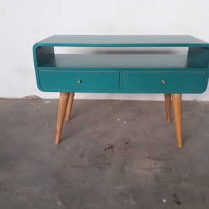 May include: Teal blue side table with two drawers and a shelf. The table has rounded edges and four wooden legs.
