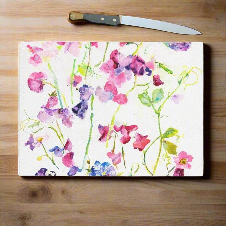 Sweet peas glass chopping board made of toughened glass and heat resistant glass so perfect for as serving platter for hot food, as cheese board or as a chopping board. The pretty design of Sweet peas makes a decorative addition to the kitchen and as ideal gifts for Mum