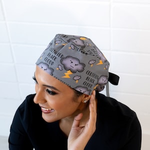 Puede incluir:  gorro de quirófano gris con un patrón de nube negra y rayo. El texto "Certified Black Cloud" se repite en el gorro.