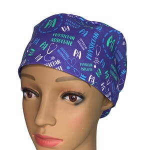 May include: Purple scrub hat with a repeating pattern of the words "Physician Associate" and "PA" in green and white text. A stethoscope is also included in the pattern.