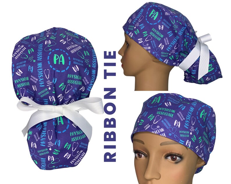 May include: A purple and blue scrub hat with a white ribbon tie. The hat has a repeating pattern of the text "Physician Associate" and the letters "PA" in a circle.