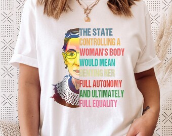 May include: White t-shirt with a colorful graphic of Ruth Bader Ginsburg and the text "THE STATE CONTROLLING A WOMAN'S BODY WOULD MEAN DENYING HER FULL AUTONOMY AND ULTIMATELY FULL EQUALITY".
