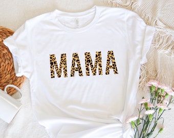 May include: White t-shirt with the word "MAMA" printed in a leopard print pattern.
