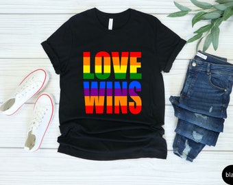 May include: Black t-shirt with the text "LOVE WINS" in rainbow colors.