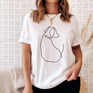 May include: White t-shirt with a black line drawing of a dog on the front.