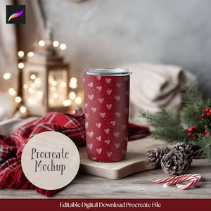 May include: A red tumbler with a white heart pattern and a silver lid. The tumbler is displayed on a wooden surface with a red plaid scarf, pine cones, and candy canes. The text "Procreate Mockup" is visible.