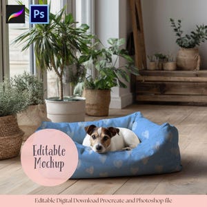 May include: A small dog rests in a blue dog bed with a white heart pattern. The bed is rectangular and has a soft, cushioned appearance. The words "Editable Mockup" are in a pink circle. The image also includes Procreate and Photoshop icons.