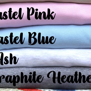 May include: A stack of four folded sweatshirts in different colors. The colors are pastel pink, pastel blue, ash, and graphite heather.