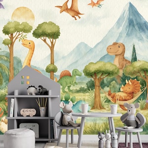 May include: A children's playroom scene with a dinosaur theme. The image shows a gray bookshelf, table, and chairs, decorated with soft toys and ornaments. The backdrop is a mural depicting dinosaurs, trees, mountains, and pterodactyls in watercolour.