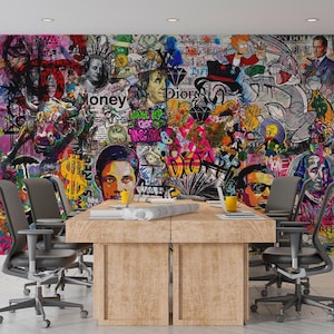May include: A conference room with a large wooden table and gray office chairs. The wall is covered in a vibrant graffiti mural featuring portraits, cartoon characters, and dollar signs. The mural has a mix of colors.