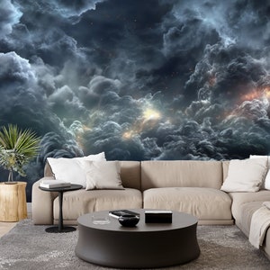 May include: A dark blue and gray abstract cloud formation with bright yellow and orange light bursts. The image is used as a wall mural in a living room with a beige sectional sofa and a black coffee table.