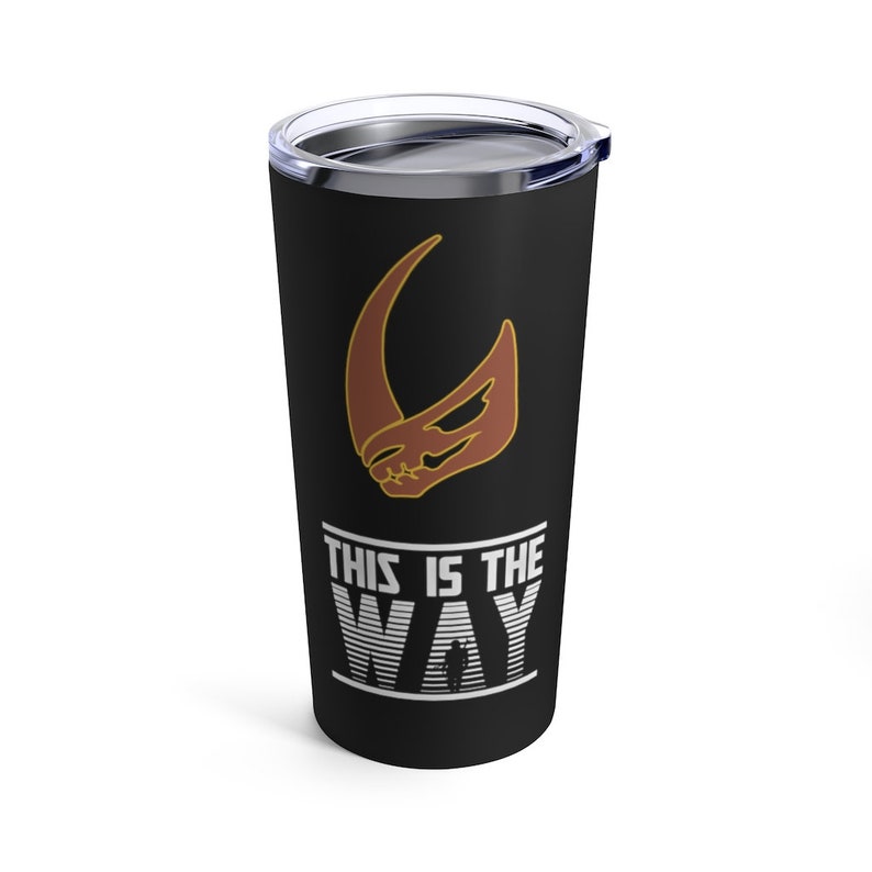 Op de afbeelding: Een zwarte roestvrijstalen tumbler met een Mandaalorian symbool en de tekst "This is the Way" in wit. Het symbool is in bruin en goud.