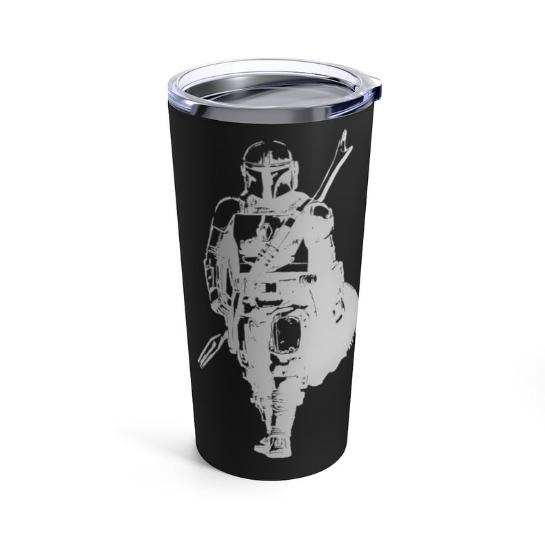 Puede incluir: Un vaso de acero inoxidable negro con una silueta blanca de un personaje mandaloriano sosteniendo un arma. El personaje lleva un casco y una armadura.