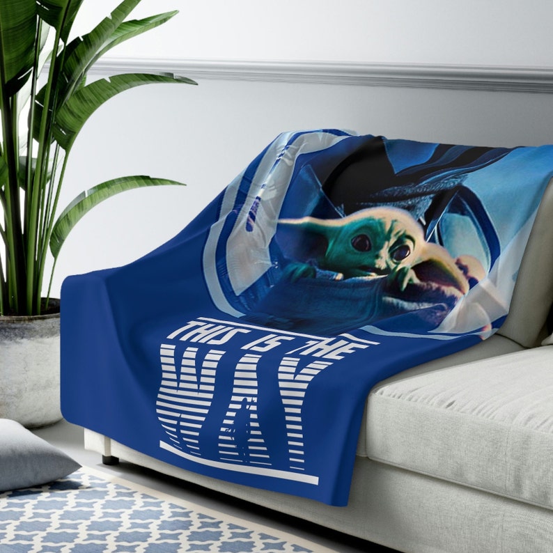 May include: Blue throw blanket with a white and blue striped design that says "This is the Way" with a picture of a character from the Star Wars series, The Mandalorian.
