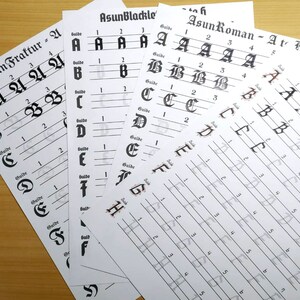 May include: A set of four calligraphy practice sheets with different alphabet styles: Asun Fraktur, Asun Blackle, Asun Roman, and Asun Hollow. Each sheet has a guide line and numbered spaces for practicing letters.