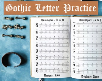 May include: A white notebook with black lines and gray letters for practicing Gothic calligraphy. The notebook is open to two pages, each with a different set of letters from A to H. The title of the notebook is "Gothic Letter Practice".