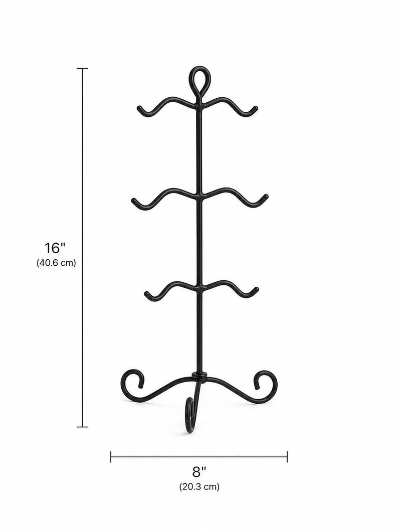 May include: Black metal mug rack, 40.6 cm tall and 20.3 cm wide. The rack has a hook at the bottom and four curved arms to hold mugs. The top has a decorative loop.