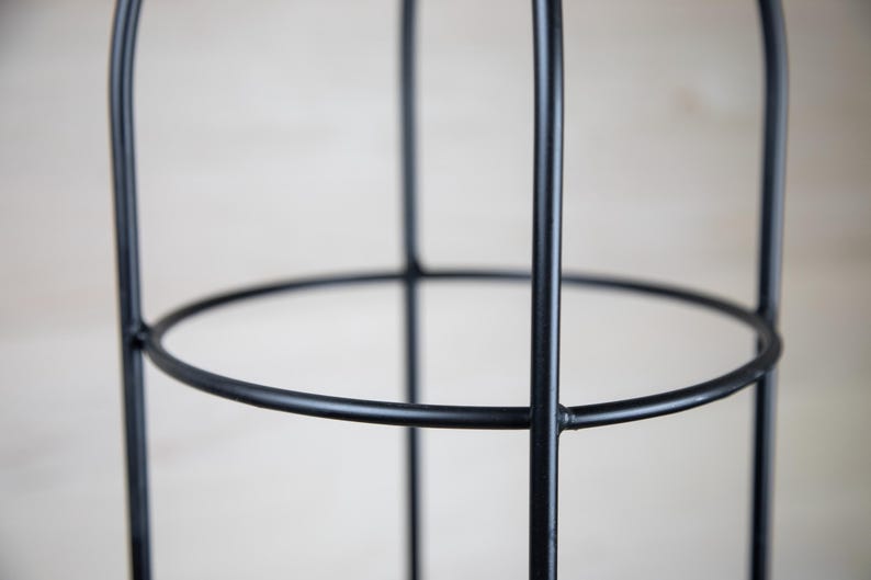 May include: Black metal plant cage with a circular design. The cage is made of sturdy metal and has a simple, modern look.