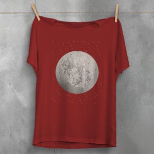 May include: A red t-shirt with a white moon and stars graphic print.
