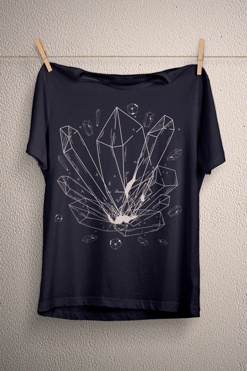May include: A dark blue t-shirt with a white graphic of geometric crystals. The crystals are arranged in a cluster and have a detailed, intricate design.