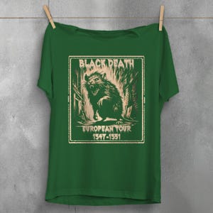 May include: Green t-shirt with a vintage-style graphic of a rat in a city alley. The graphic says "Black Death European Tour 1347-1351".
