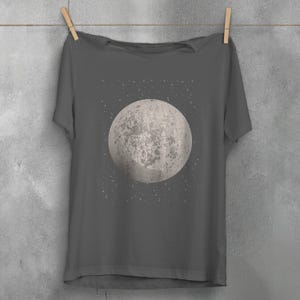 May include: A dark gray t-shirt with a white moon and stars graphic print.