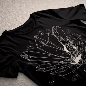 May include: Black t-shirt with a white graphic design of geometric crystals. The design features multiple crystals of different shapes and sizes.