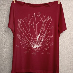 May include: A red t-shirt with a white geometric design of crystals on the front.