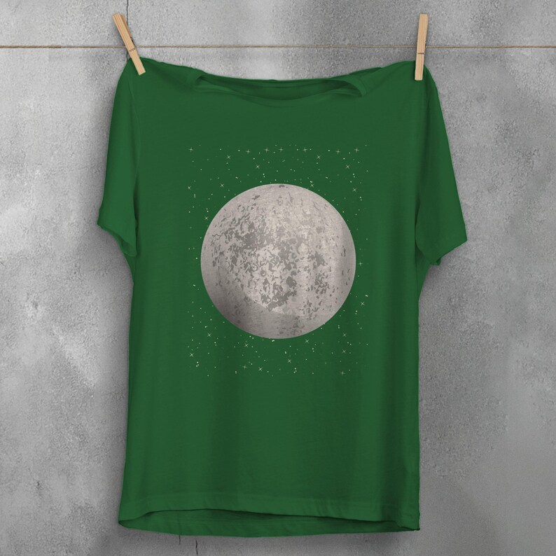 May include: A green t-shirt with a white moon and stars graphic print.