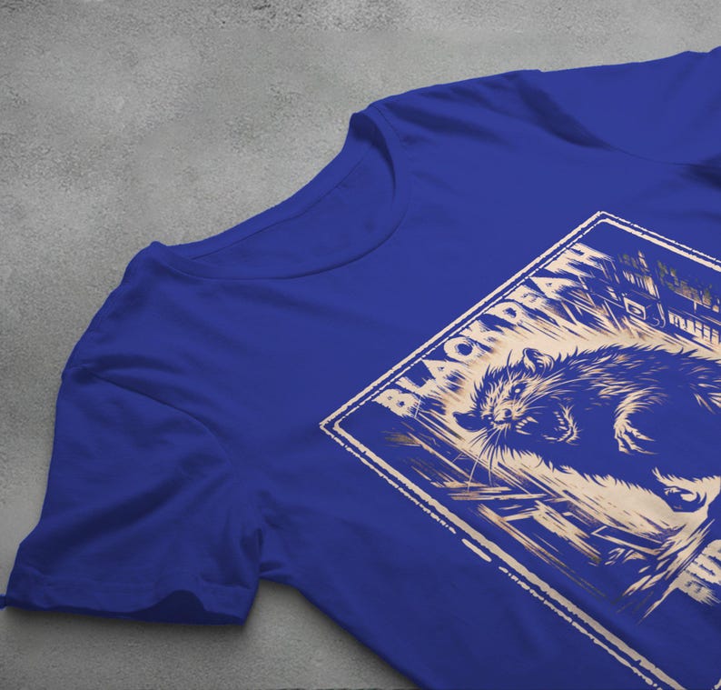 May include: A royal blue t-shirt with a vintage-style graphic of a snarling rat in front of a building. The graphic is in a light beige color and has the text "Black Death" in a stylized font.