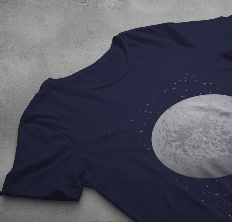 May include: A navy blue t-shirt with a white moon and stars graphic print.