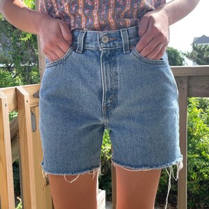 K&ouml;nnte beinhalten: Eine hellblaue Jeans-Shorts mit ausgefranstem Saum. Die Shorts haben einen hohen Bund und sind aus einem weichen, bequemen Stoff.