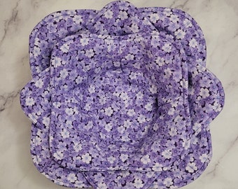 May include: Two purple fabric bowls with a floral pattern. The bowls are nested inside each other.