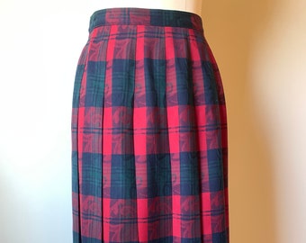 May include: A red and green plaid skirt with a pleated design. The skirt is made of a woven fabric and has a mid-length hemline.