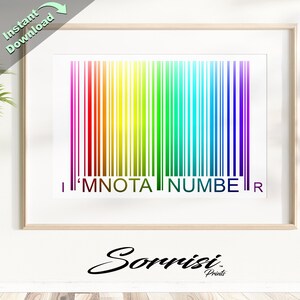 Puede incluir: Un código de barras arcoíris colorido con el texto "I'M NOT A NUMBER" impreso debajo. El código de barras está enmarcado en un marco de madera claro. El texto "Sorrisi Prints" está impreso debajo del marco.