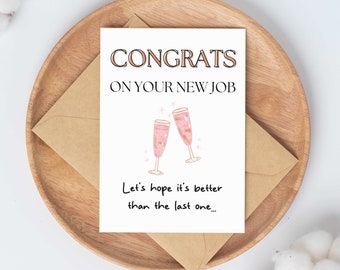 May include: A white card with the text "CONGRATS ON YOUR NEW JOB" and a drawing of two champagne flutes. The text below the drawing says "Let's hope it's better than the last one..."