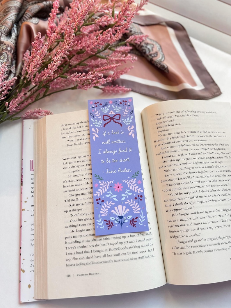 May include: A purple and pink floral bookmark with a quote from Jane Austen that reads "If a book is well written, I always find it to be too short."