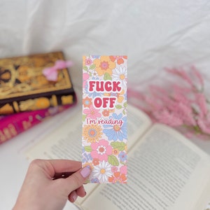 May include: A pink, blue, and yellow floral bookmark with the text "F**k Off I'm reading".